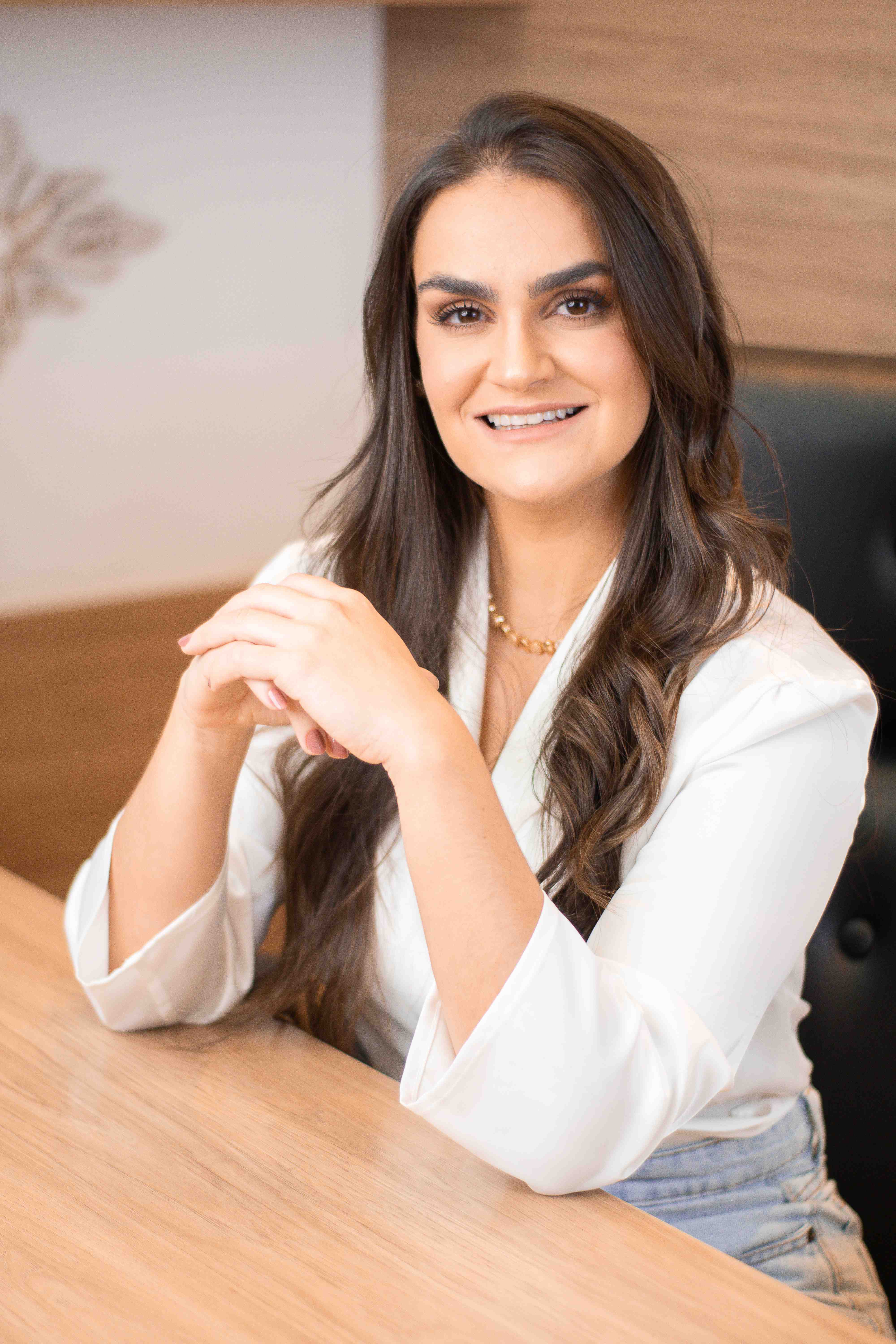 Dra. Vanessa Tayer, ginecologista e obstetra, sorrindo em seu consultório